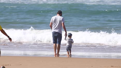 Entspannter-Vater-Und-Sohn-Spazieren-An-Einem-Sommertag-Am-Strand-Entlang