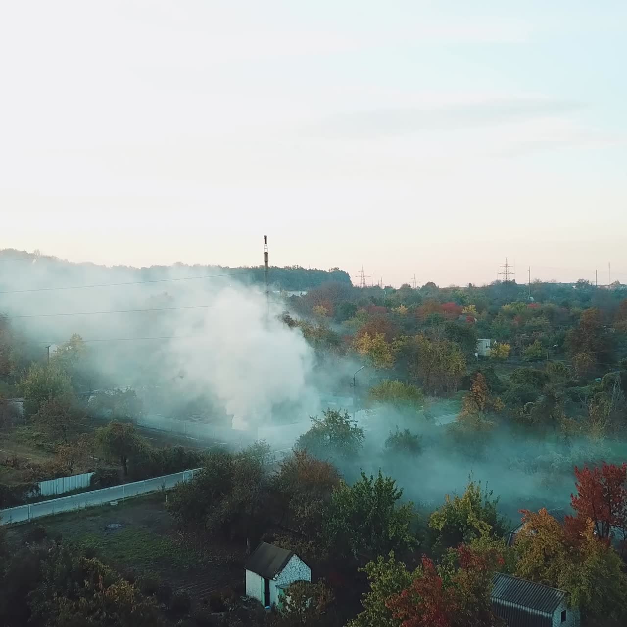 white clouds of smoke is covering the countryside as a result of fire in hot summer weather. Aerial view