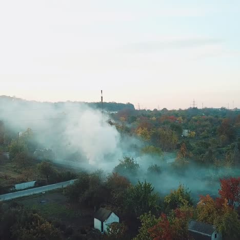 white clouds of smoke is covering the countryside as a result of fire in hot summer weather. aerial view
