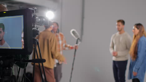 actores frustrados y directora filmando una escena de película o video en el estudio mientras el grabador de sonido deja caer el micrófono en la toma