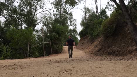 Man-hiking-in-Griffith-Park-on-path,-Los-Angeles,-California