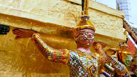 colorful statues supporting temple structure in bangkok