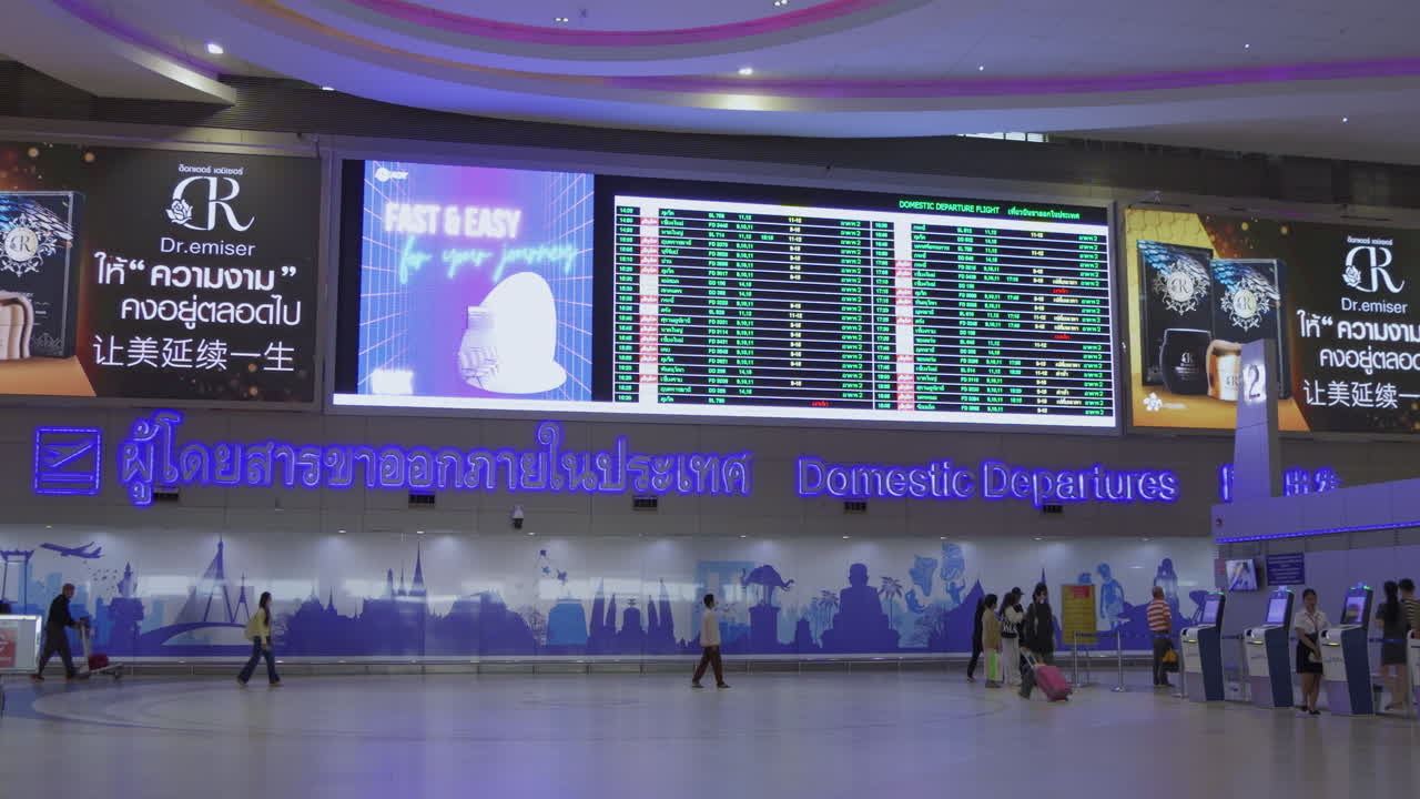 A view of the domestic arrival signboard and flight schedule inside Don Mueang Airport, capturing the continuous air travel activity. Ideal for airport and travel themes.