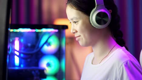 close up of excited asian teen girl gamer celebrates victory and dancing while playing video game on computer