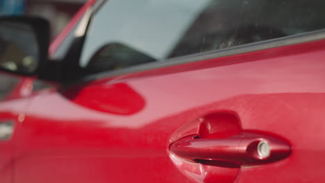 Young-woman-with-long-red-hair-gets-into-modern-automobile