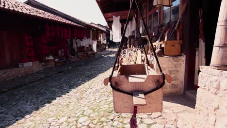 old wooden cradle swinging from ropes in old marketplace