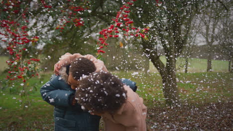 dos niños divirtiéndose jugando en la nieve en una caminata de invierno en el campo - filmado en cámara lenta