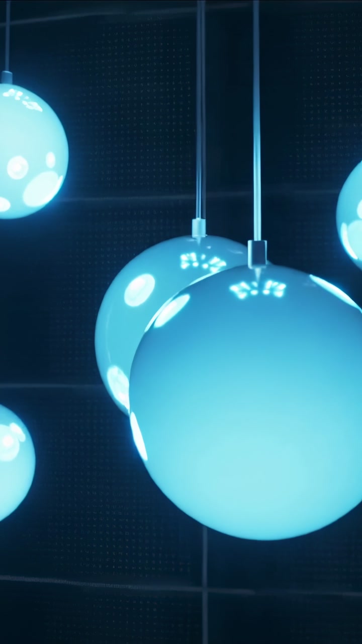 Vertical video: Moving camera filming blue orbs shifting closer by grid wall to highlight spots