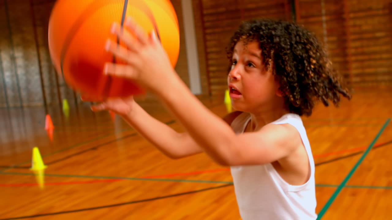 estudiante atlética afroamericana jugando al baloncesto en la cancha de baloncesto de la escuela 4k