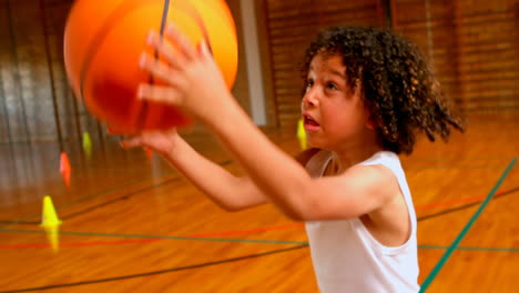 athletic african american schoolgirl playing with basketball in basketball court at school 4k