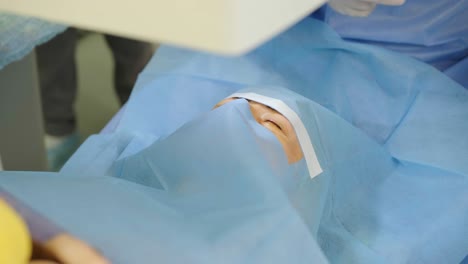 laser vision correction. a patient and team of surgeons in the operating room during ophthalmic surgery