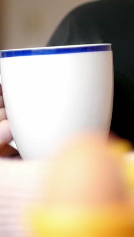 mujer usando el teléfono móvil mientras toma café