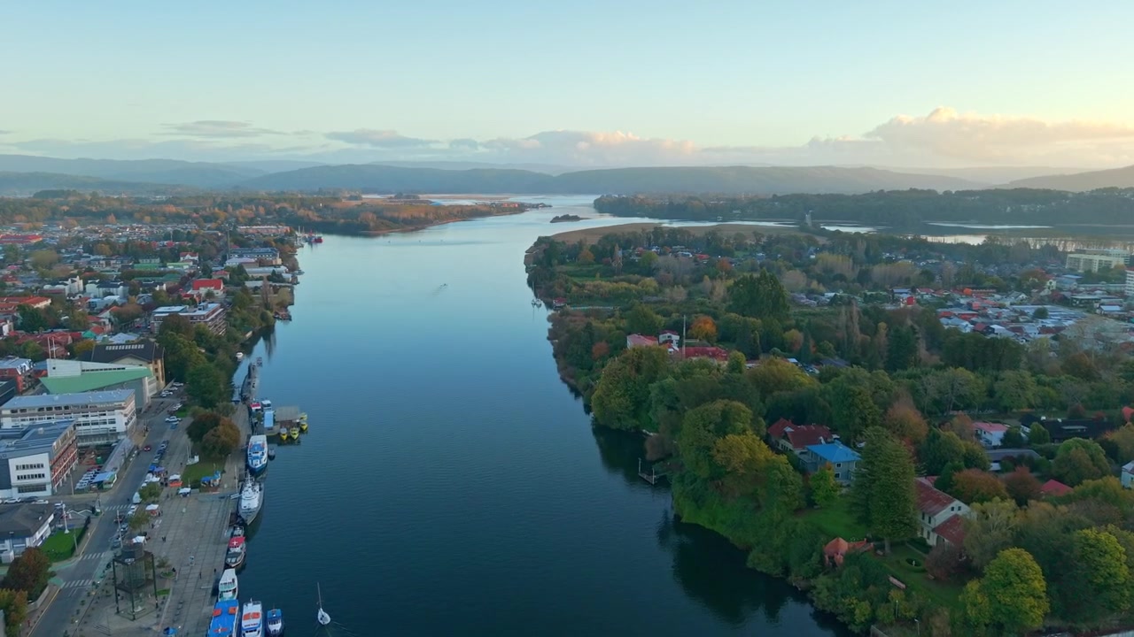 Dolly aereo in avanti sul fiume CalleCalle con la città di Valdivia e Isla Teja, Cile, paesaggio naturale urbano