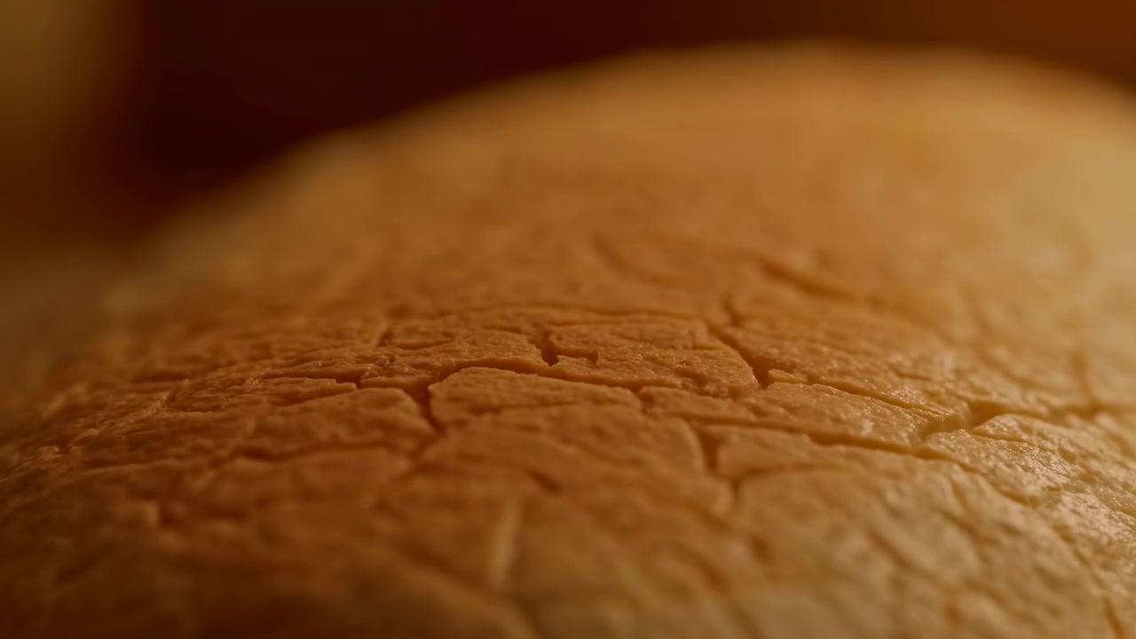 Très gros plan d'une surface texturée beige chaud avec une légère crête horizontale, de douces micro-plis, une faible profondeur de champ, une lumière diffuse, un fond abstrait organique, des tons neutres et calmes, et un détail tactile.
