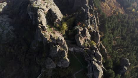 Drone-hovering-above-the-Belogradchik-Rocks-and-slowly-pulling-away-to-reveal-the-Balkan-mountain-ranges-in-the-background,-in-Vidin-province,-Northwestern-Bulgaria