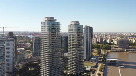 modern high-rise buildings tower over the riverfront in buenos aires, against a sprawling city backdrop