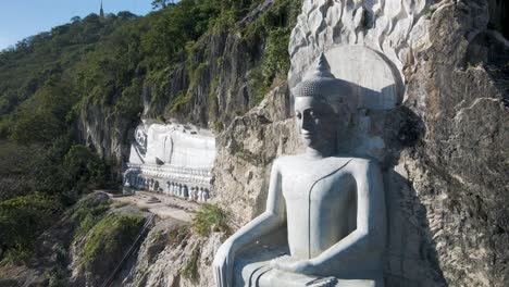 Giant-Earth-Touching-Buddha-casting-shadows-in-the-early-morning-light,-carved-in-mountain-rock-face-at-Phnom-Sampov,-Cambodia