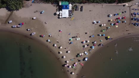 people relaxing on italy sandy coastline, aerial top down view