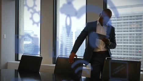 animation of digital icons over businessman using tablet