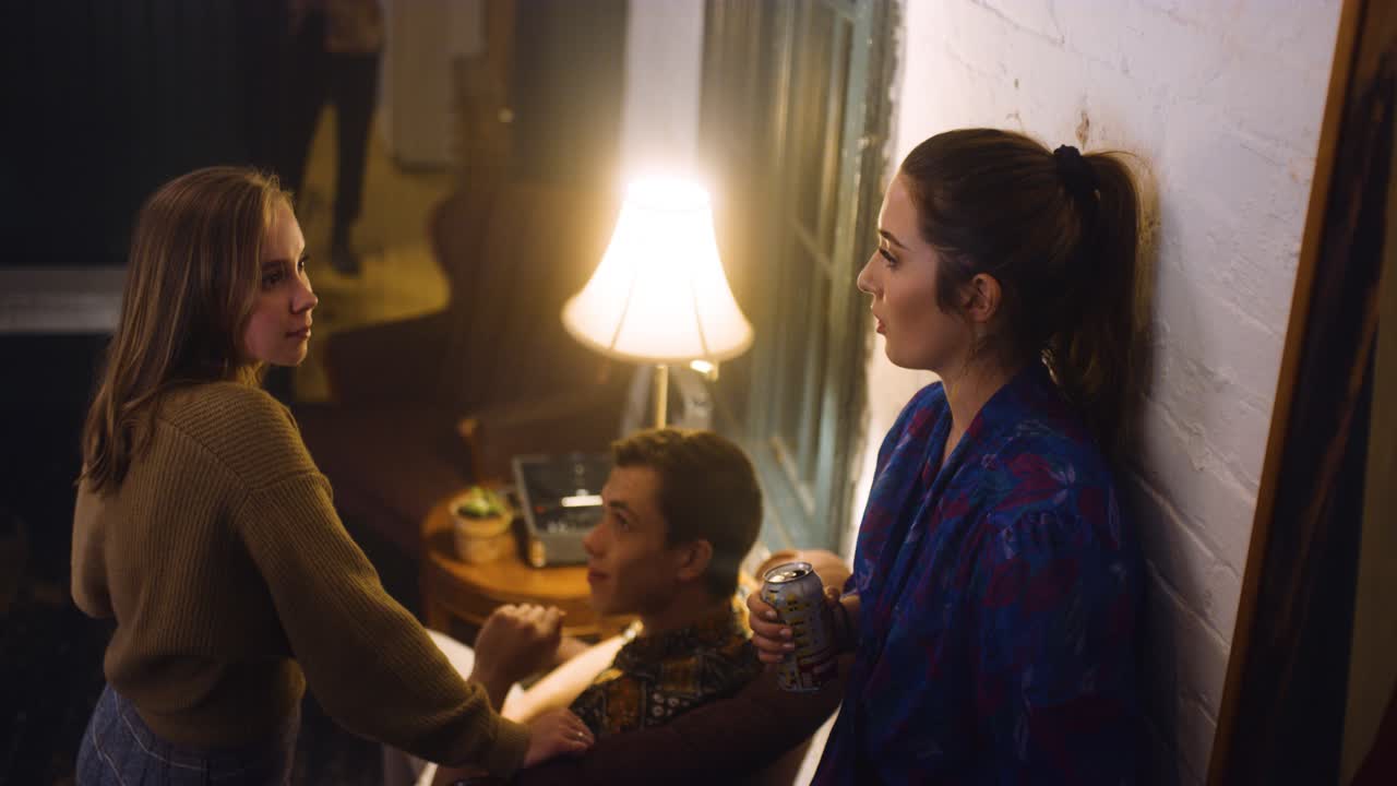 People talk at a house party.