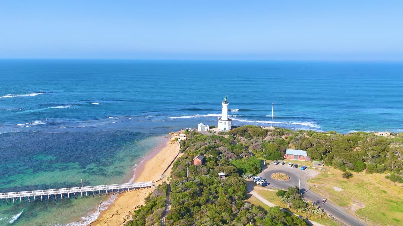 Aerial footage captures Point Lonsdale lighthouse, ocean waves, and coastal landscape under clear blue skies