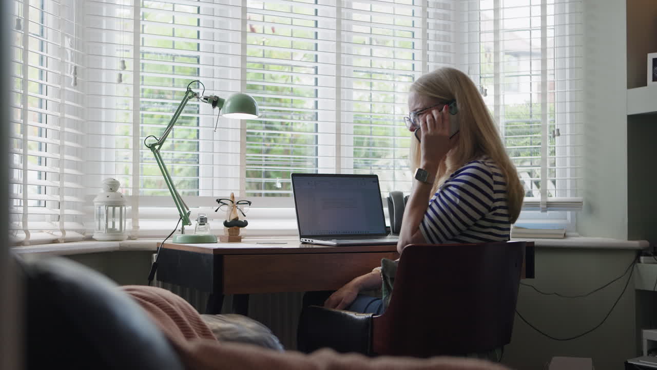 Woman working at desk in front of window
