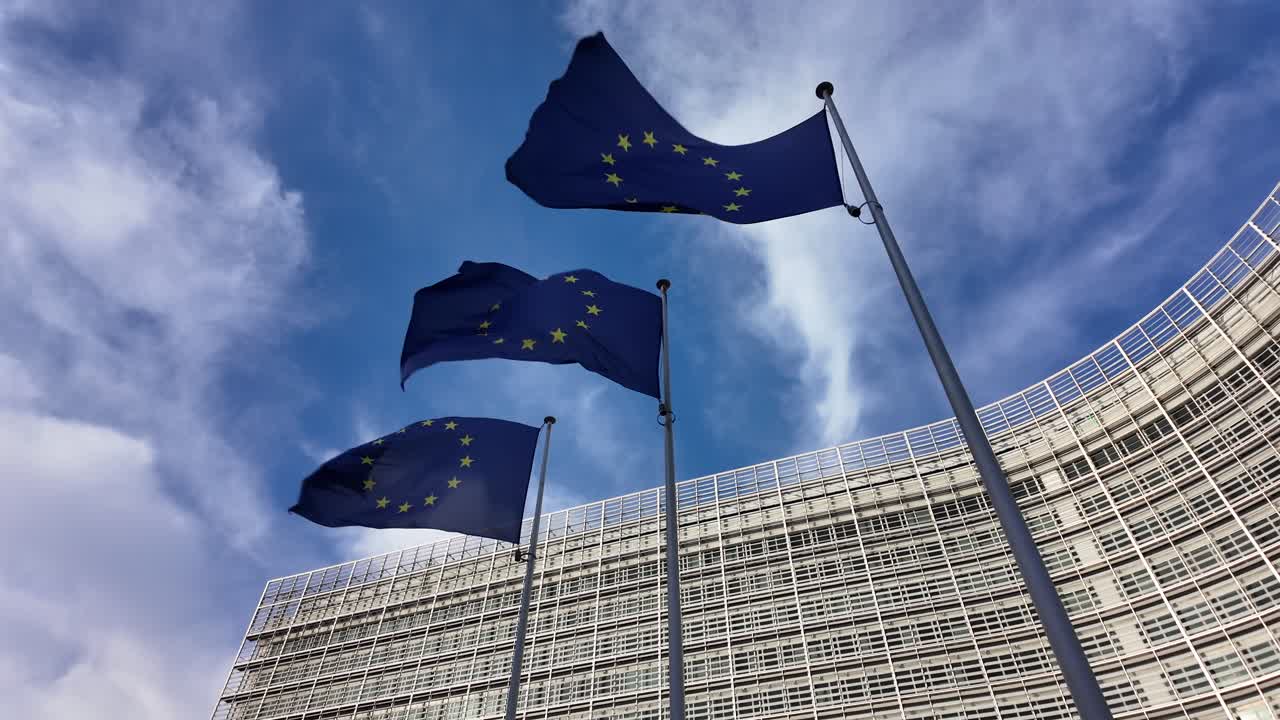 Bandiere dell'Unione Europea al rallentatore che sventolano vicino al palazzo Berlaymont a Bruxelles