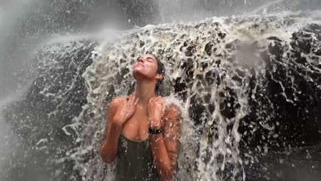 una hermosa joven brasileña en traje de baño sonriendo y mirando hacia arriba y disfrutando nadando bajo la cascada de mosquitos en chapada diamantina en el noreste de brasil en el estado de bahia de vacaciones