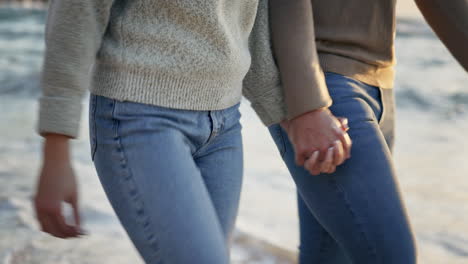 couple, closeup and holding hands at the beach