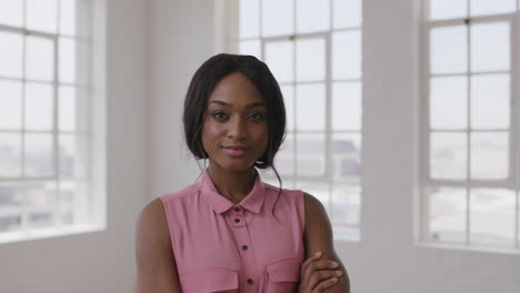 slow motion portrait of young stylish african american woman smiling confident looking boss at camera arms crossed in windows background