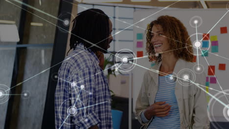 Animation of network of connections against diverse man and woman discussing at office