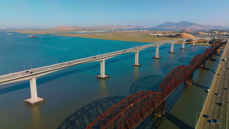 three neighboring bridges over blue calm water of carquinez strait. martinez-benicia bridges with lots of cars on. sunny clear day footage.