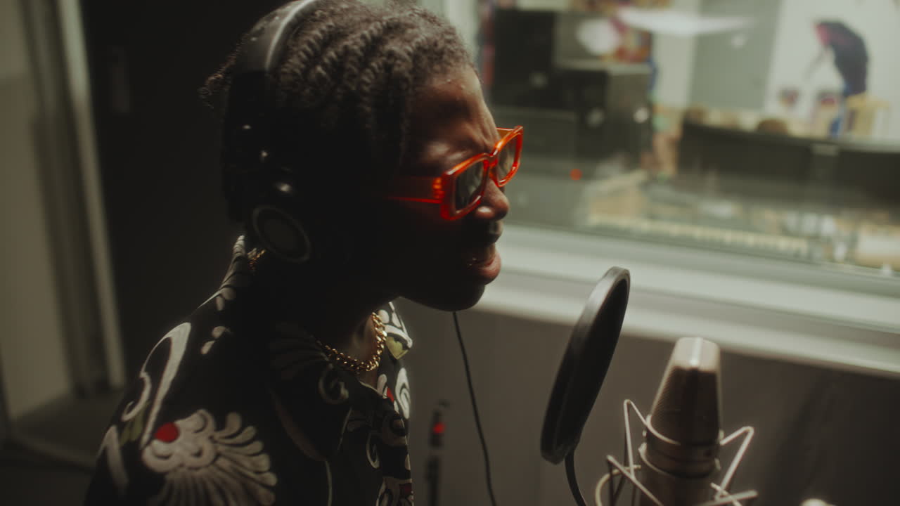 Vibey Black Musician Recording Song in Professional Studio Booth