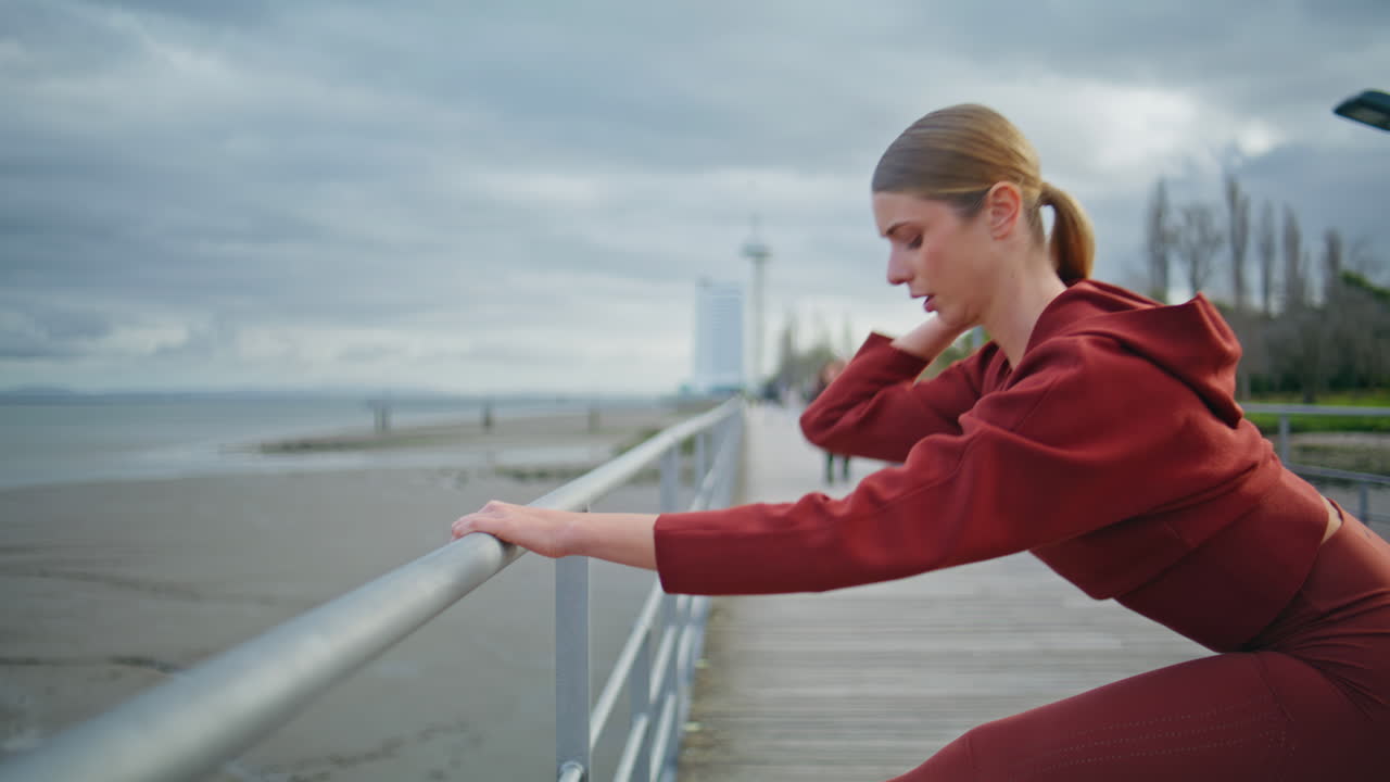Girl runner warming legs before marathon sprint. Closeup athlete bending body