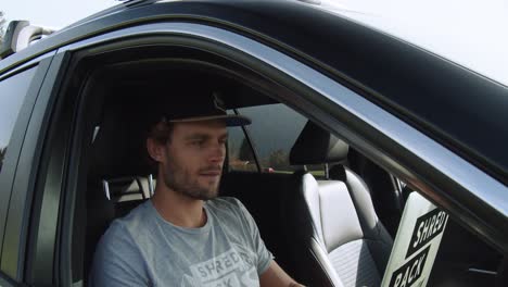 Medium-shot,-front-view-a-man-working-in-a-car-working-with-a-laptop