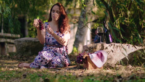 girl picks a grape from a cluster and eats it long shot