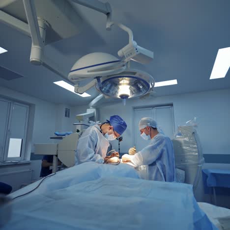 neurosurgery in contemporary clinic. male medical specialists perform a surgery in the operating room. professional surgeons doing an operation to a patient.