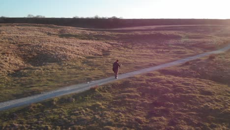 orbital shot of man walking towards ribblehead viaduct at sunset