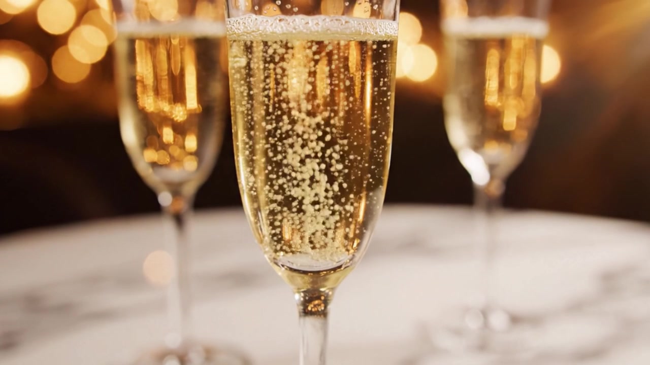 Una celebrazione della vita: Bicchieri di champagne scintillanti che mostrano bollicine ed eleganza, perfetti per brindisi e occasioni speciali in un'atmosfera calda e accogliente.