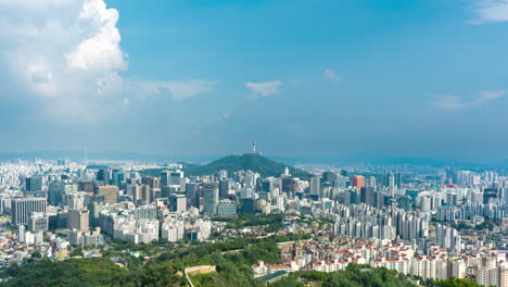 seoul city urban cityscape viewed from inwangsan mountain peak, seoul city wall fortification, namsan tower iconic landscape - static time lapse on sunny day with slow floating clouds in blue sky