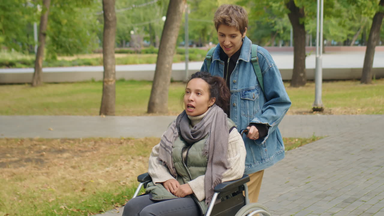 Woman in Wheelchair on Walk in Park with Friend