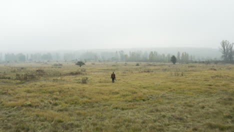 dokumentarfilmer mit einer kamera, der in einem nebligen moorland, herbst, tschechien spaziert