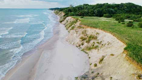 golden-hour sunlight bathes latvia’s rugged baltic sea cliffs, waves shape shore