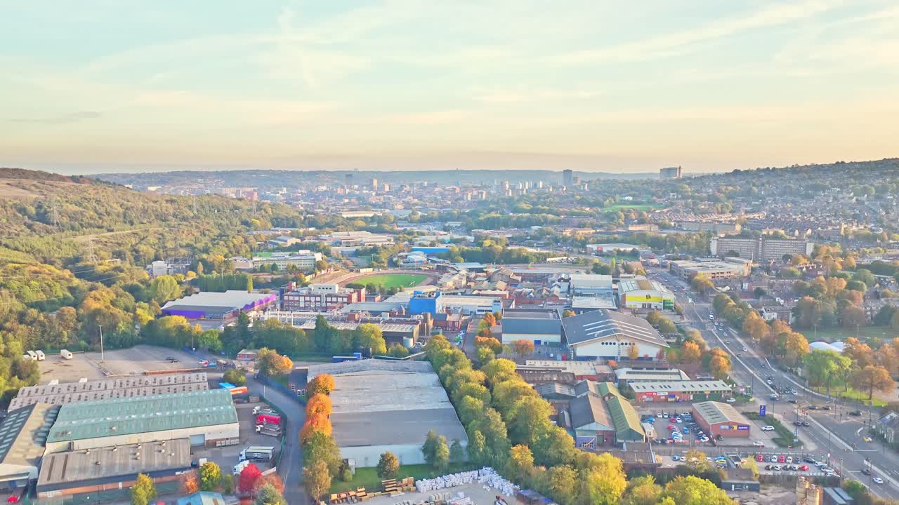 Slow ascending shot unveils Sheffield’s sprawling industrial estate, tree-lined roads, city skyline and wooded hills stretching to the horizon as afternoon light fills the valley
