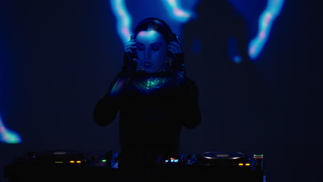 female dj mixing music on turntables in a nightclub