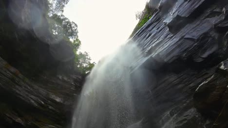 Hermosa-Cámara-De-Acción-Giratoria-En-Cámara-Lenta-Tomada-Desde-Debajo-De-La-Impresionante-Cascada-De-Mosquitos-Mirando-Hacia-El-Parque-Nacional-Chapada-Diamantina-En-El-Noreste-De-Brasil-Con-Agua-En-La-Lente