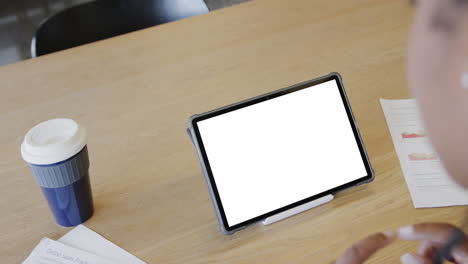 mujer de negocios afroamericana en una videollamada de tableta con pantalla en blanco