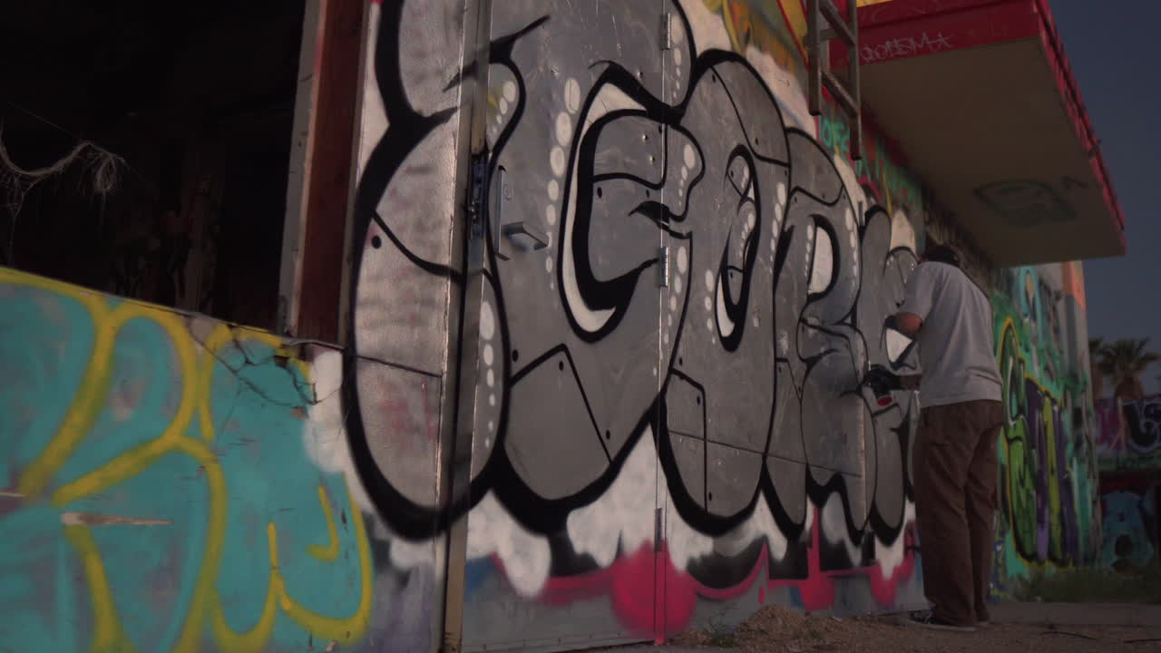 Graffiti Artist at Work on a Building Wall