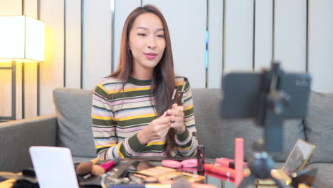 donna che fa vlog sui cosmetici con lo smartphone