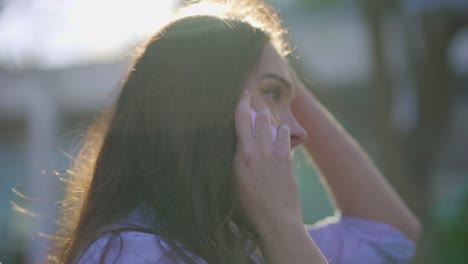 Primer-Plano-De-Una-Mujer-Caucásica-Hablando-Por-Teléfono,-Corrigiendo-El-Cabello